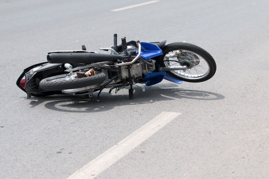 motorcycle lying on its side in the road after a crash